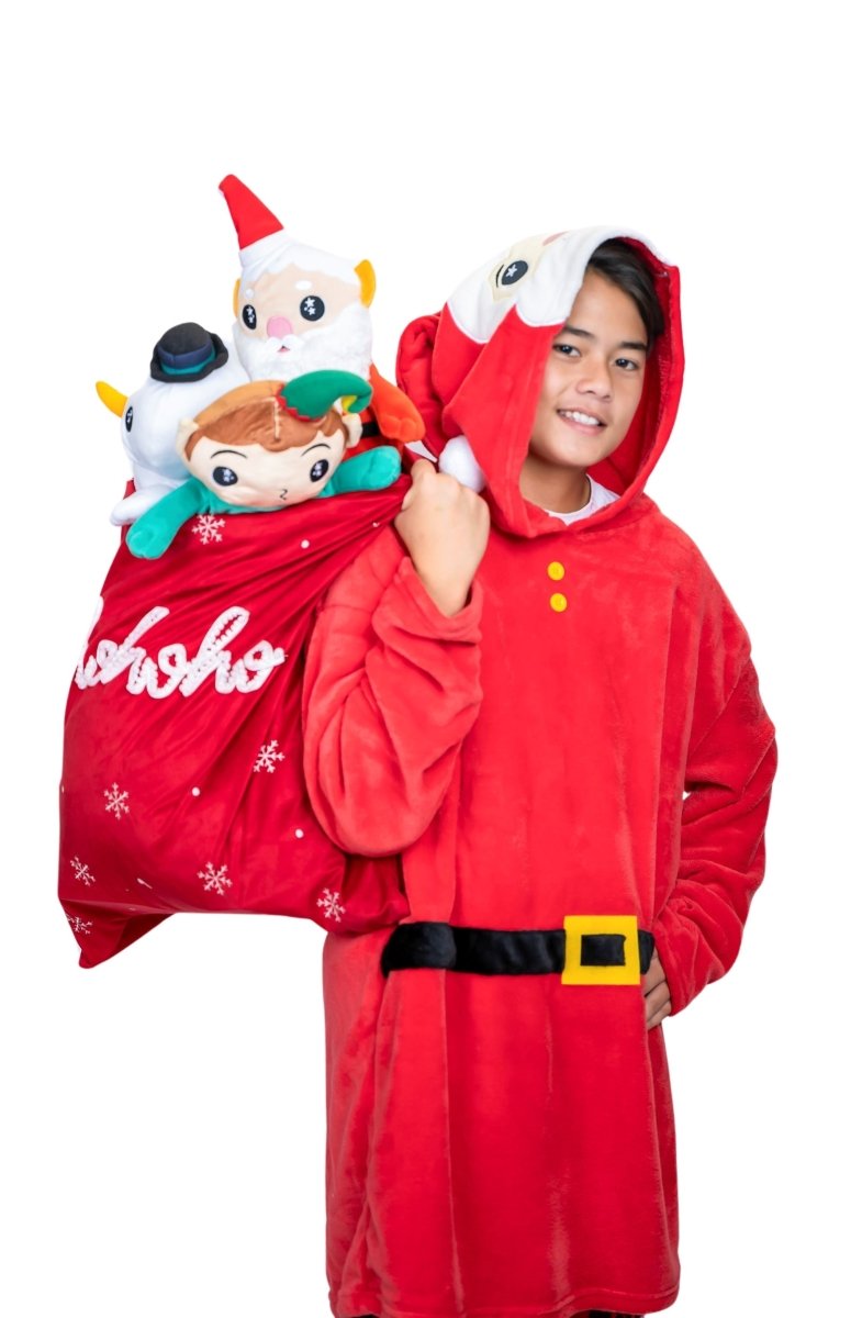 A person in a Santa Hooded Blanket grins while holding a large red sack with "Ho Ho Ho" on it. The overflowing bag is filled with Christmas-themed plushies against a plain white background.