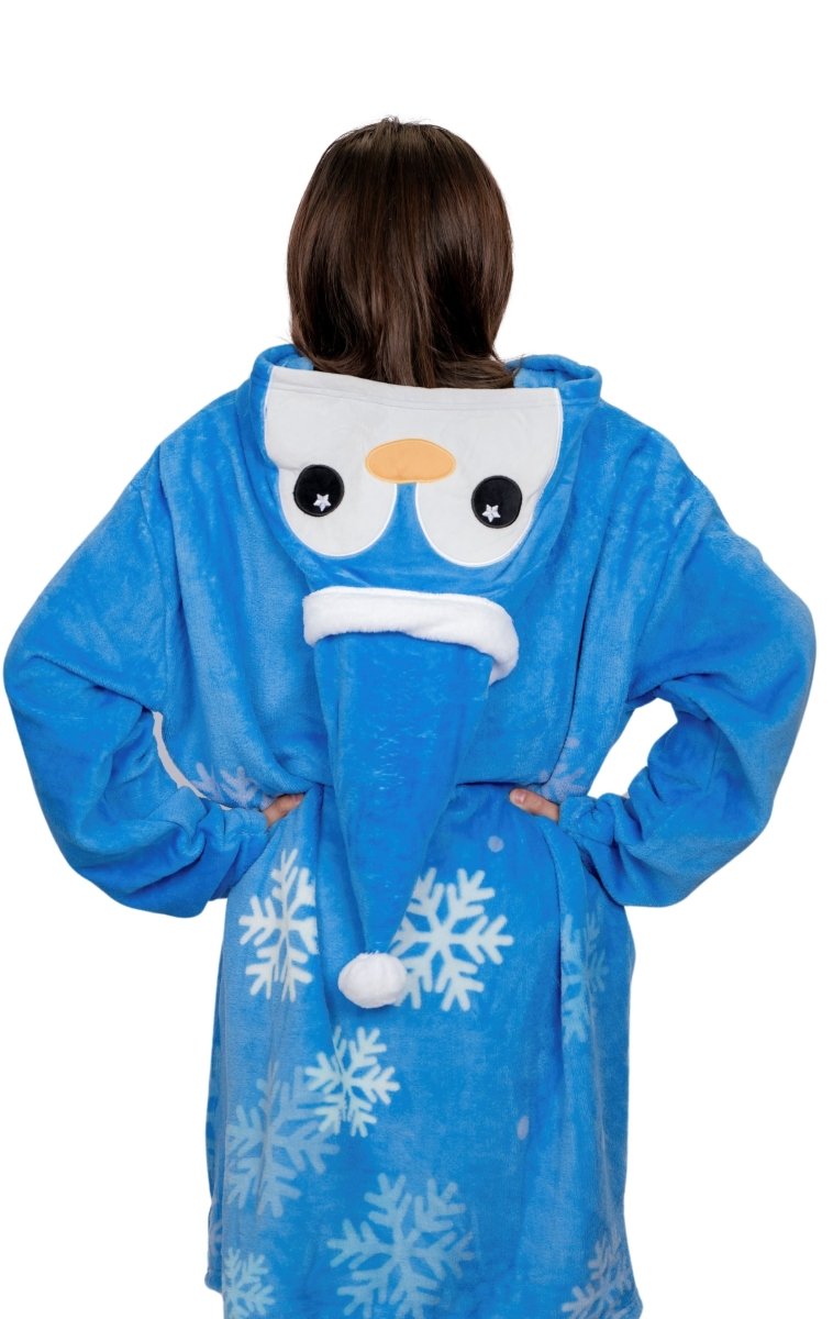 A person seen from behind wearing Peckington the Penguin Hooded Blanket, featuring a blue design with white snowflake patterns and a playful cartoon face on the hood. Made of soft fleece, it’s perfect as a cozy holiday gift.