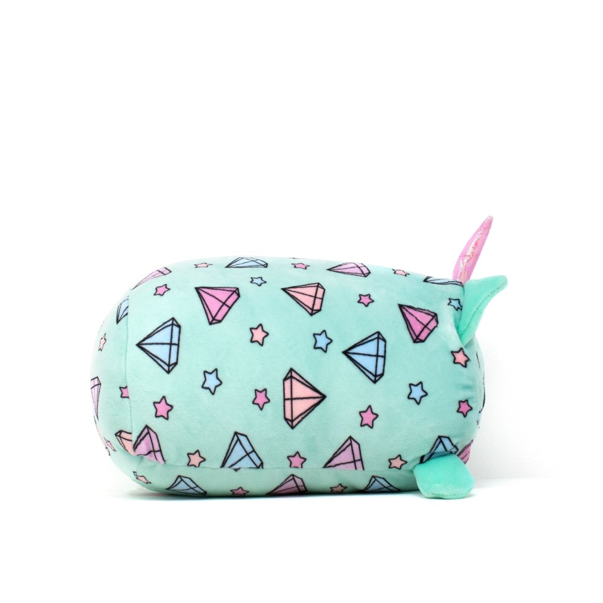 Blossom - Slumber Plushie is a narwhal-shaped plushie with a turquoise body, colorful diamond shapes, and stars in pink and blue. It features a pink tusk and fins, making it ideal for cuddling or as a charming collectible addition.